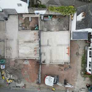 Aerial view of a construction site with exposed foundations and surrounding buildings.