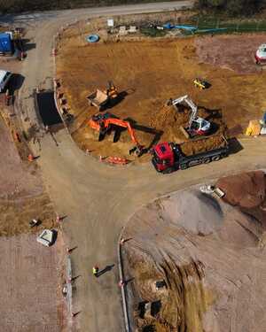 Aerial view of a construction site with vehicles, equipment, and earthworks.