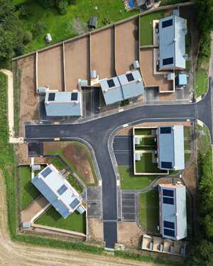 Aerial view of a residential development with several houses and surrounding land.