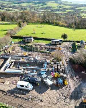Construction site at Wodetone Vineyard, surrounded by green fields and trees.
