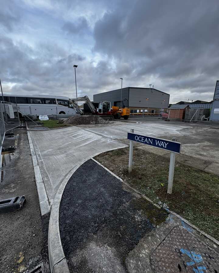 Sign for "OCEAN WAY" at an industrial area with cloudy skies in the background.