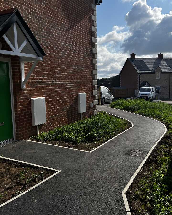 Workers pouring concrete on a construction site, with tools and materials scattered around.
