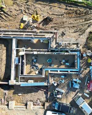 Aerial view of a construction site at Wodetone Vineyard with a building foundation and construction equipment.